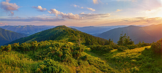 A serene mountain landscape at sunset, with golden light illuminating lush green hills and distant...