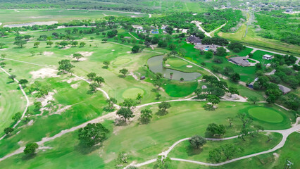 Sand trap and pond in country golf course near Hazel Park, Corpus Christi, South Texas, surrounding residential neighborhood upscale houses with swimming pool, grassy backyard, tall trees, aerial