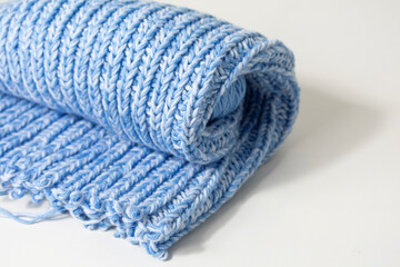 a blue knitted scarf on a white background