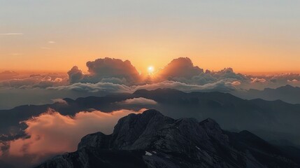 Obraz premium Majestic sunrise over mountains, with clouds and a serene atmosphere.