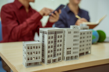 Two businessmen work at desks in an office,discussing city clean energy strategies global...