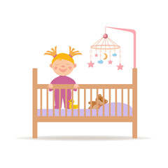 Cute infant baby is standing in crib. Newborn is learning to stand and take its first steps.