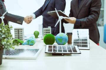 Obraz premium Three businessmen meet at a table to discuss the development of a clean energy and environmental city.Chongqing's transition to hydropower,wind power,solar power,biomass power geothermal power