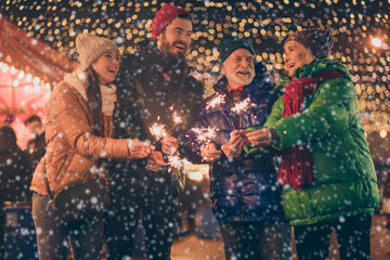 Portrait of nice attractive cheerful family having fun spending time street urban market newyear celebration burning bengal festal fire custom eve noel spirit outside outdoor