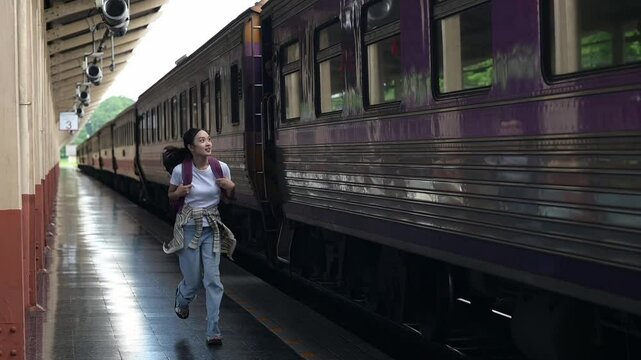Young woman running to catch departing train