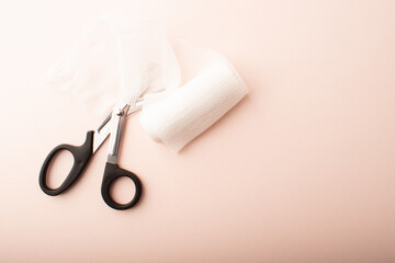 Scissors and bandage on pink background top wiev. Treatment wounds. Applying plaster to the fracture. Medical concept banner. Healthcare banner. Copy space. High quality photo