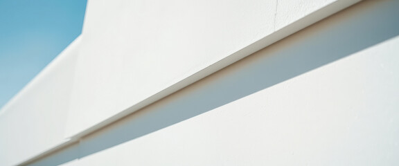 Obraz premium White Wall with Shadow and a Slight Blue Sky