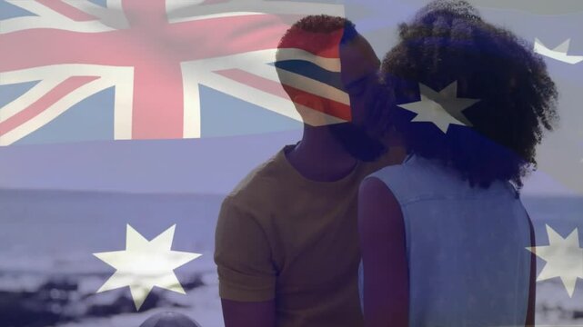 Animation of flag of australia over african american couple kissing on beach