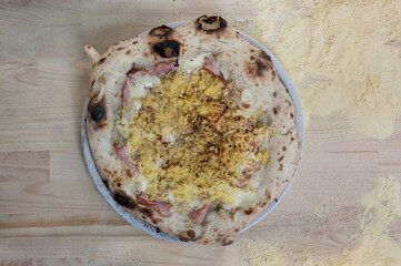Neapolitan Gateau pizza with béchamel sauce, potatoes on wooden table with flour, top view