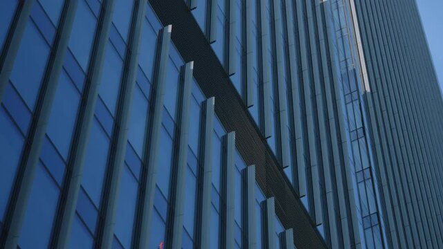 Close-up high rise skyscraper glass facade windows grid dolly shot, financial district looking up modern architecture office buildings detail, city business downtown gimbal moving camera glide