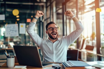 Fototapeta premium Young happy businessman celebrating success and raising both fists at his desk with laptop in modern office, showing online marketing concept ,generative ai AI.