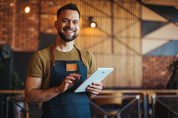 Smiling Young Barista Using Tablet in Modern Cafe