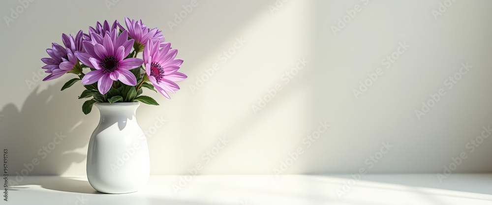 Poster Purple flowers in a white vase on a white table