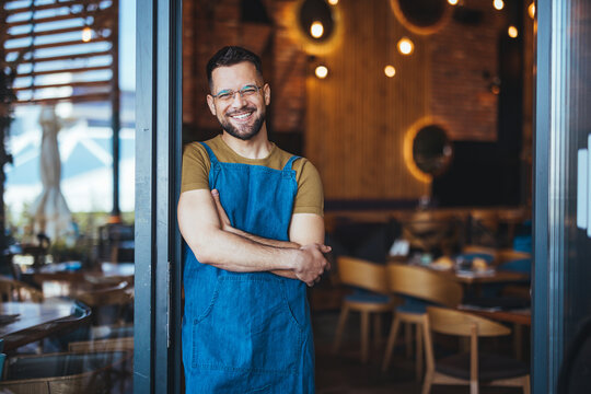 Smiling Cafe Owner Standing Proudly in Doorway