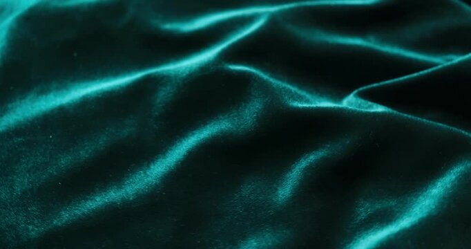Rotating green velvet fabric folds close up