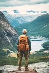 Adventurous hiker overlooking water and landscape, with backpack on.