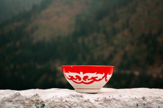 Kazakh bowl piala with national ornament. Autumn mountains on the background. Pefrect photo for Nauryz greetings. Kazakhstan, Almaty, Medeo