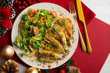 Battered anchovies, traditional Spanish tapa from the Malaga area. Table with christmas decoration.