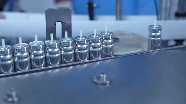 asthma inhaler, canister containers in production line. inhaler manufacturing. canister making process in a factory. asthma medicine in metal bottles on a conveyor belt. Pharmaceutical product	