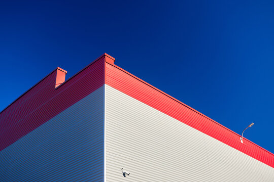 Aluminum composite panels for repair restore facade of commercial building white and red corner construction with led light flood CCTV camera outdoor wide angle with copyspace conceptual minimalism.