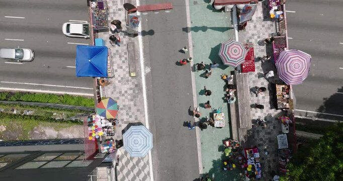 Aerial view of a bustling street market with colorful umbrellas and busy vendors, Liberdade street, Sao Paulo, Brazil.