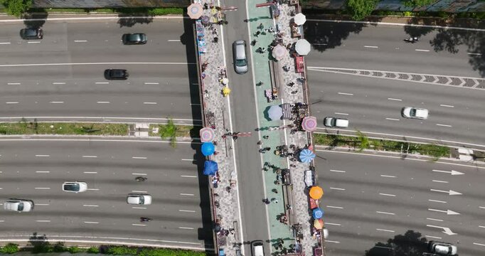 Aerial view of vibrant and bustling Liberdade street with colorful umbrellas and busy market activity, Sao Paulo, Brazil.