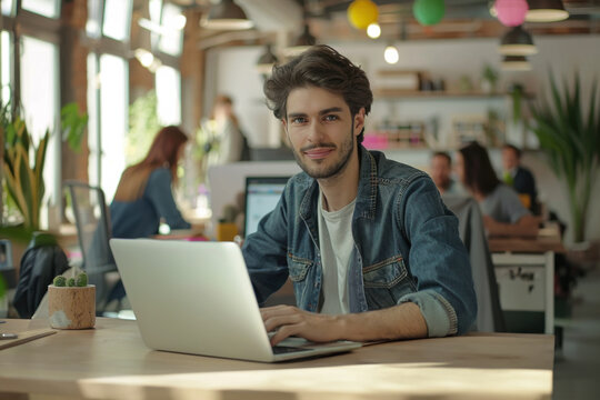 Smiling student studying in a modern library. Young man thinking and problem solving school exercises. Male using laptop computer to work on a university research project online