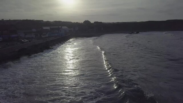 Aerial view of serene sunset over calm ocean waves and tranquil shoreline, Eyemouth, United Kingdom.