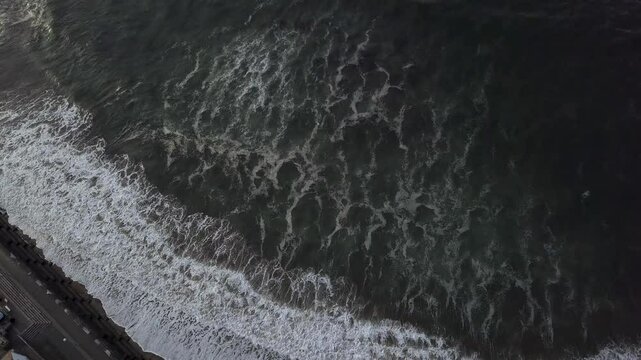 Aerial view of beautiful coastline with crashing waves and serene beach, Eyemouth, United Kingdom.