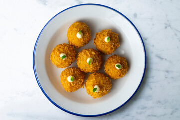 Spanish Tapa croquettes made with bechamel sauce and stuffed fish and mayonnaise. Top view table.