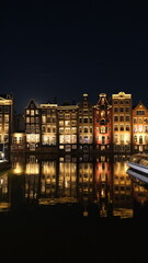 Obraz premium Night city street facade reflection in Amsterdamer canal water