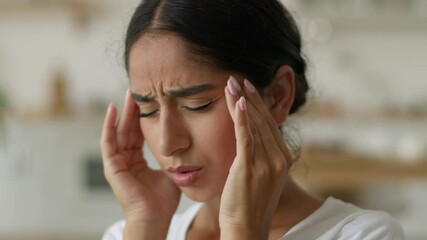 Ill sick tired exhausted fatigued suffering bad feeling Arabian woman Indian girl lady female at home migraine pain headache painful head symptom health problem medicine painkiller stress pressure - Powered by Adobe