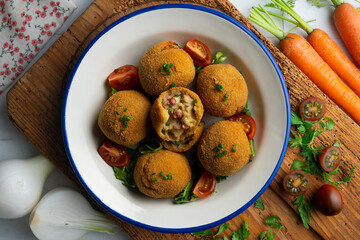 Spanish Tapa croquettes made with bechamel sauce and stuffed with octopus and potato. Top view table.