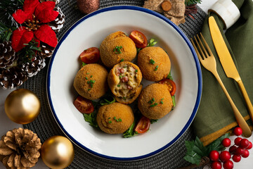 Spanish Tapa croquettes made with bechamel sauce and stuffed with octopus and potato. Top view table with christmas decoration.
