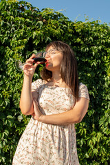 Obraz premium Young attractive woman drinking red wine
