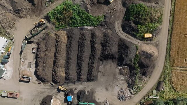 Aerial view of composting site with machinery and compost piles surrounded by fields, East Linton, Scotland.