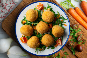 Spanish Tapa croquettes made with bechamel sauce and stuffed with iberian ham. Top view table with christmas decoration.