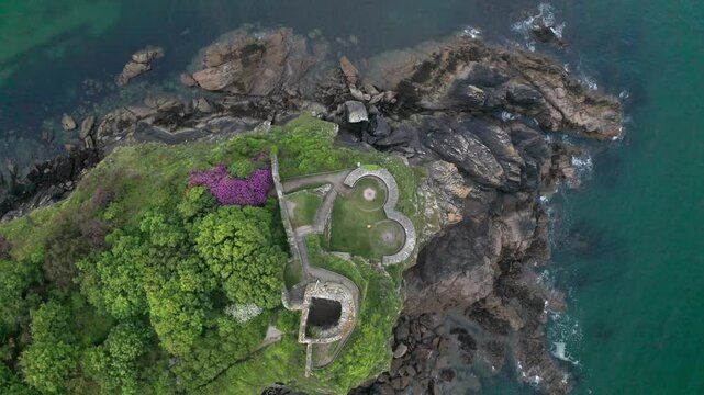 Aerial view of st cathrines castle on a rocky coastline surrounded by greenery and the sea, fowey, united kingdom.