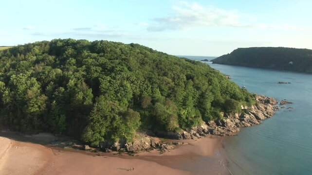 Aerial view of serene Mill Bay with lush greenery and rocky cliffs, Salcombe, United Kingdom.