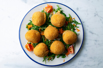 Spanish Tapa croquettes made with bechamel sauce and stuffed with iberian ham. Top view table with christmas decoration.