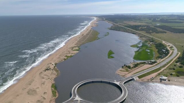 Aerial view of laguna garzon bridge connecting the ocean and lagoon with scenic coastline, Maldonado, Uruguay.