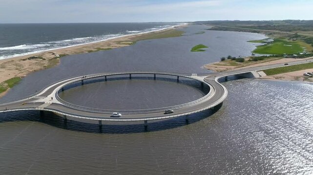 Aerial view of Laguna Garzon Bridge with cars crossing over a serene waterway, Maldonado, Uruguay.