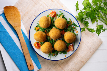 Spanish Tapa croquettes made with bechamel sauce and stuffed with iberian ham. Top view table with christmas decoration.