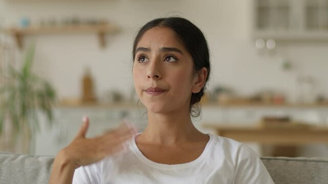 Overheated Indian woman at home wave hand refresh tired cool with arms unhappy sweaty Arabian lady girl female suffer of high temperature problem feel sweat hot without air conditioner climate control