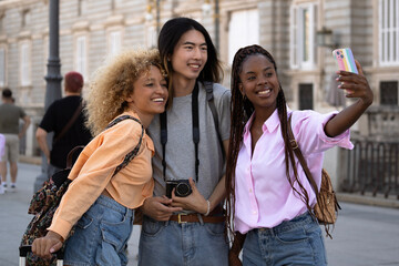 Multiethnic tourists young friends taking a selfie while visiting madrid city