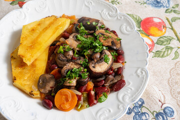 Mushroom feijoada with grilled pineapple and peanut sauce. A plant-based twist on the classic Brazilian dish, combining savory and sweet flavors, perfect for vegans and food enthusiasts.