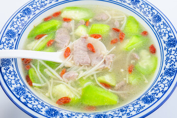 A bowl of loofah, lean meat, enoki mushroom soup