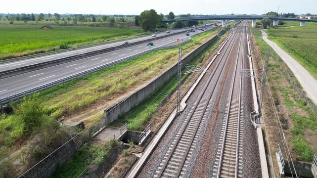 Europe, Italy , Milan 09,14,2024  - Frecciarossa Trenitalia  Hight speed 300km h train railway  view from the drone - the faster way to travel in Italy from Milan to Rome. A1 motorway , cars and train