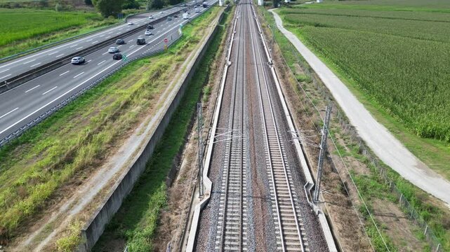 Europe, Italy , Milan 09,14,2024  - Frecciarossa Trenitalia  Hight speed 300km h train railway  view from the drone - the faster way to travel in Italy from Milan to Rome. A1 motorway , cars and train