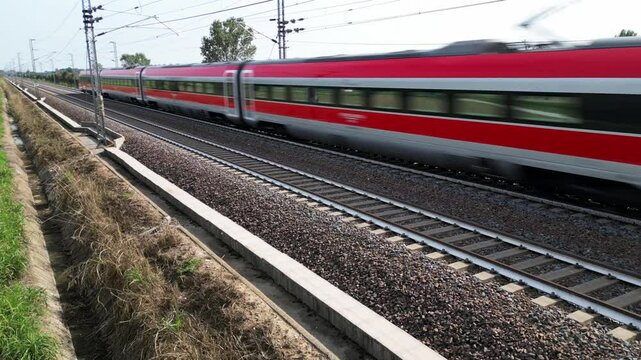 Europe, Italy , Milan 09,14,2024  - Frecciarossa Trenitalia  Hight speed 300km h train railway  view from the drone - the faster way to travel in Italy from Milan to Rome. A1 motorway , cars and train